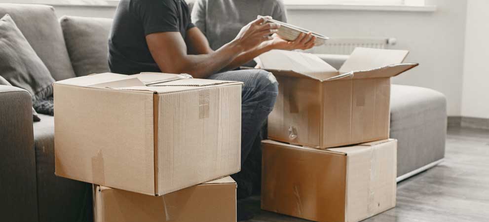 Couple packing their valuables carefully in boxes before Get Done Moving starts relocation